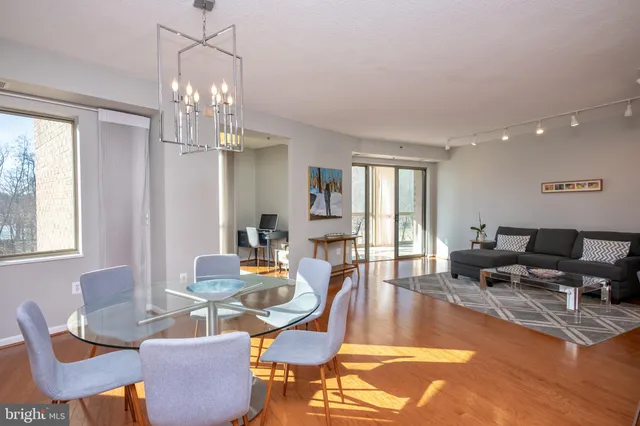 a living room with furniture a chandelier and a dining table