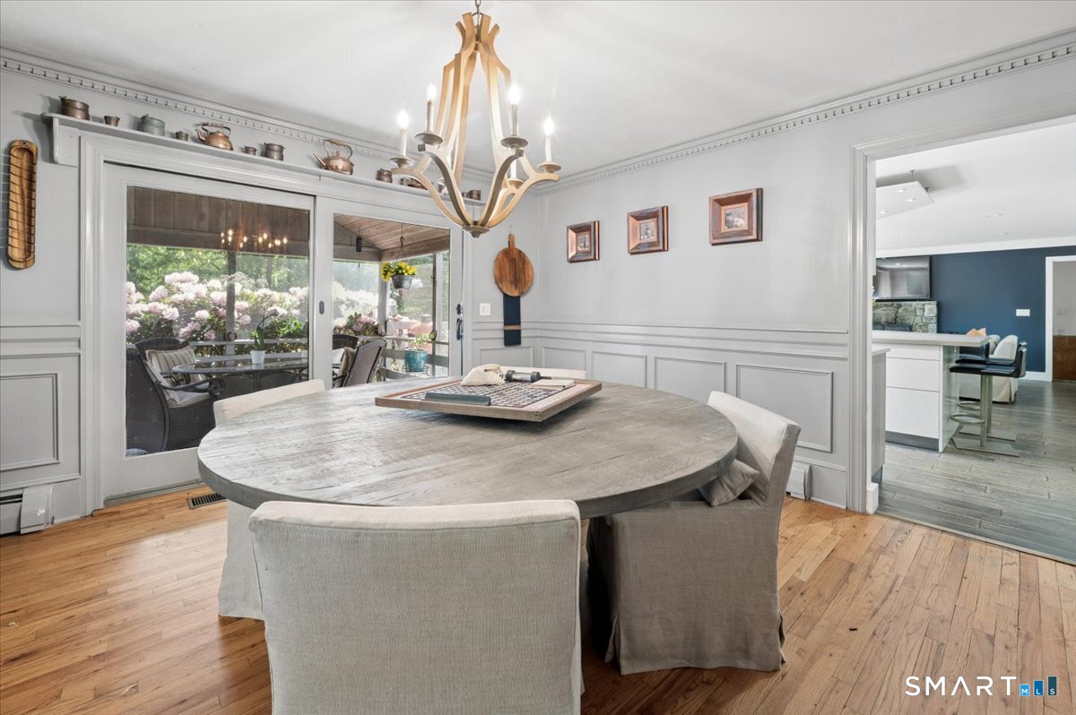 94 Vista Road Wilton, CT 06897 - Photo 10 of 38 a dining room with furniture a chandelier and wooden floor
