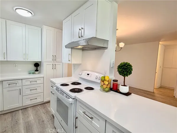 a kitchen with white cabinets and appliances
