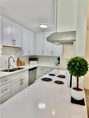 a kitchen with kitchen island a white cabinets and white appliances