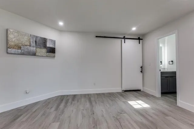a view of a hallway with wooden floor and closet
