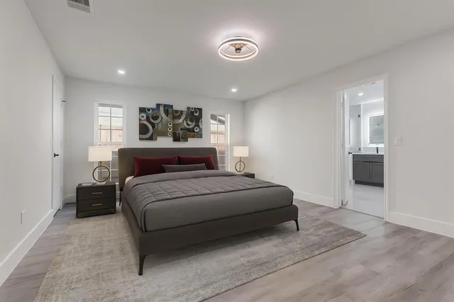 a spacious bedroom with a bed and a view of bathroom