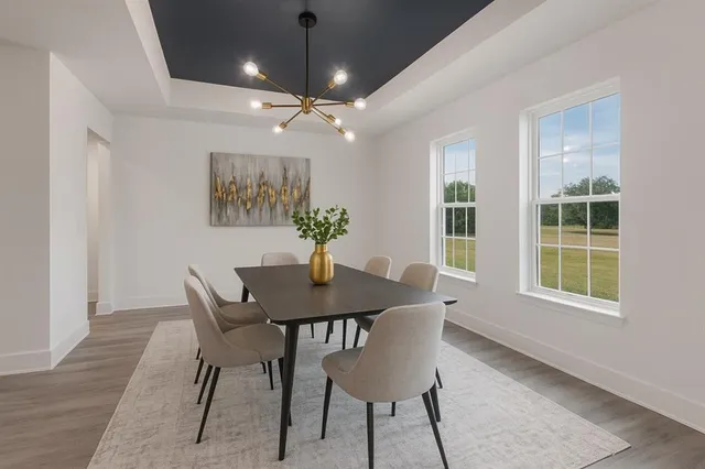 a view of a dining room with furniture a chandelier and wooden floor
