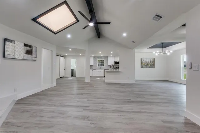 a view of a hallway with wooden floor and a ceiling fan