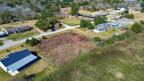 an aerial view of a house with a yard and trees