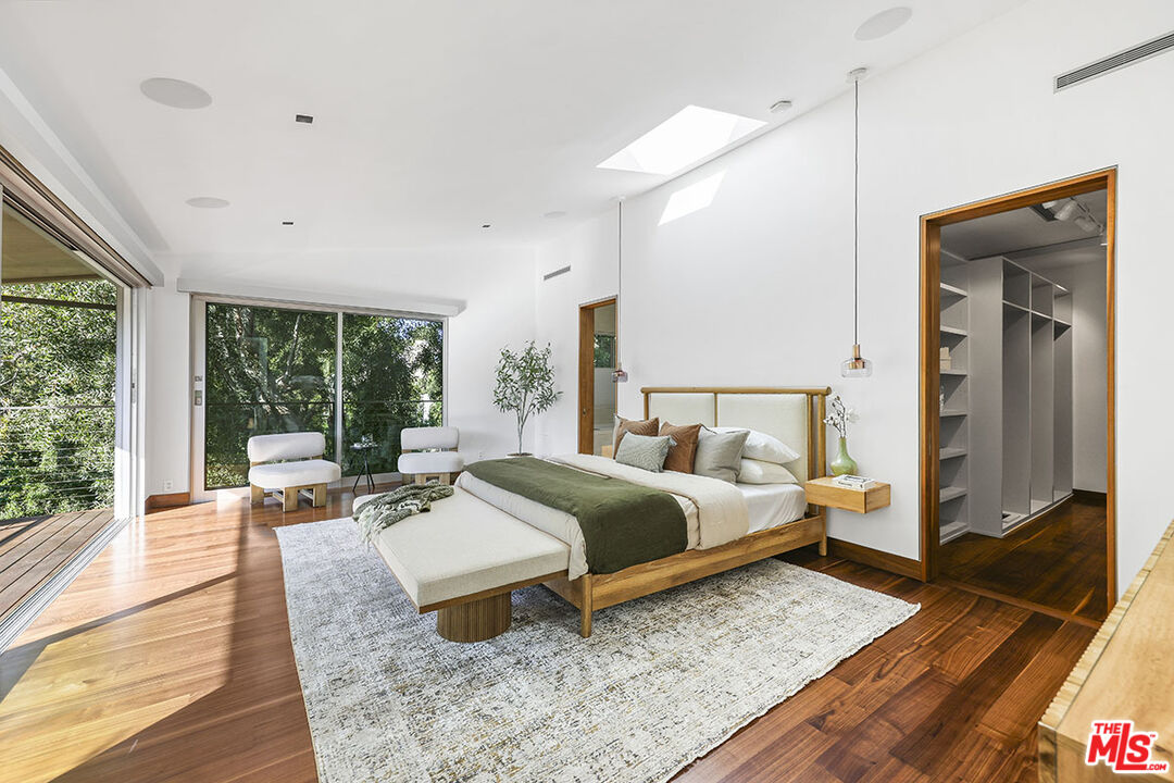612 East Channel Road Santa Monica, CA 90402 - Photo 11 of 72 a spacious bedroom with a bed a table and large window with wooden floor