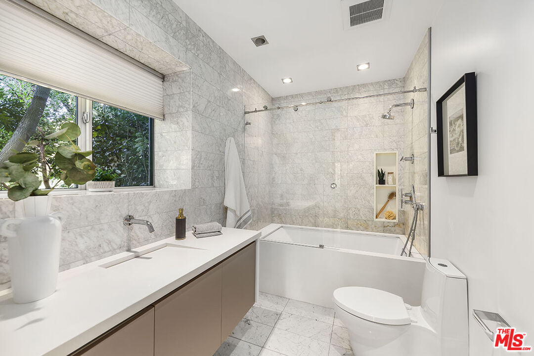 612 East Channel Road Santa Monica, CA 90402 - Photo 25 of 72 a bathroom with a sink a toilet a mirror a bathtub and shower