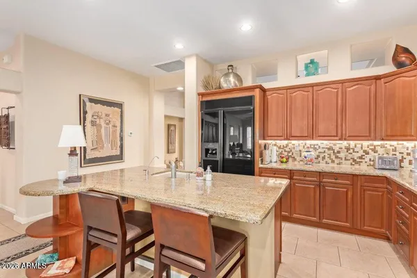 a kitchen with granite countertop a sink and a refrigerator
