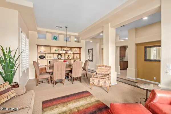 a living room with furniture kitchen view and a large window