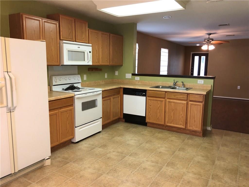 6912 Walkup Lane Austin, TX 78747 - Photo 12 of 14 a kitchen with stainless steel appliances granite countertop a stove a sink dishwasher and a refrigerator