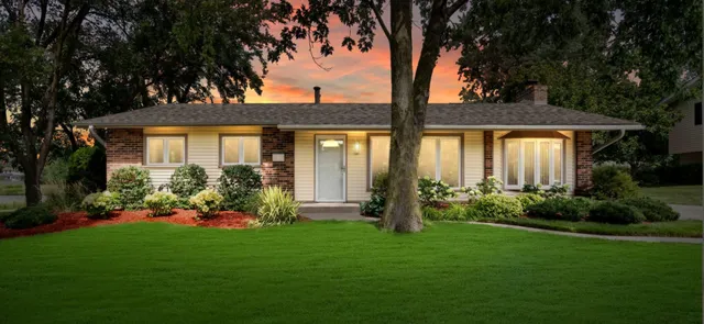 a front view of a house with a garden and yard