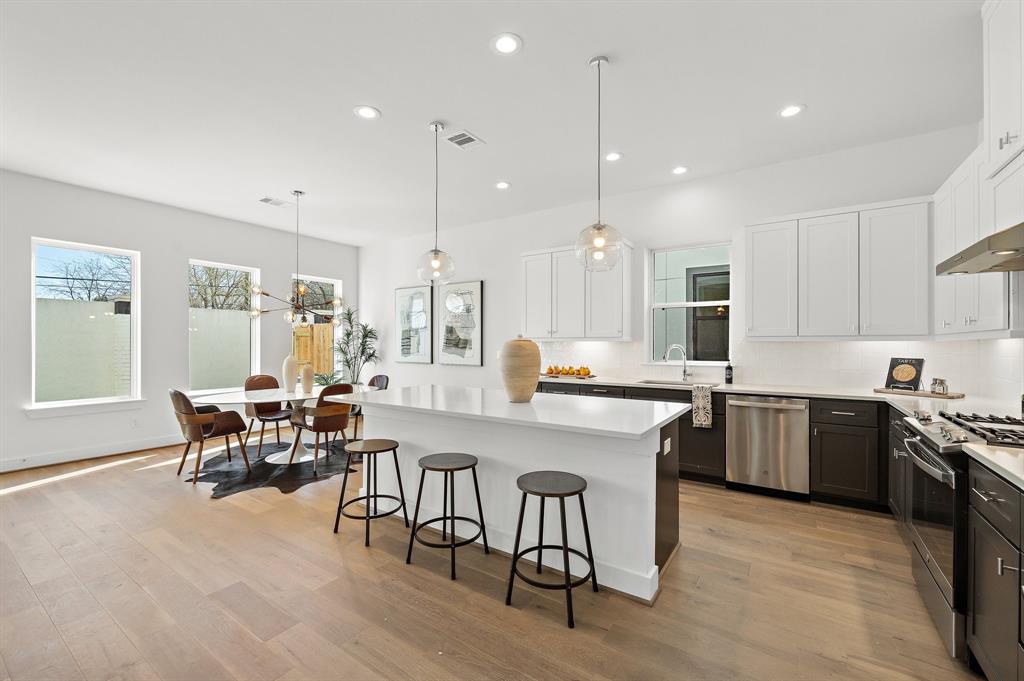 a large kitchen with kitchen island a dining table and chairs