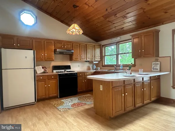 a kitchen with stainless steel appliances granite countertop a stove a sink dishwasher and a refrigerator with wooden floor