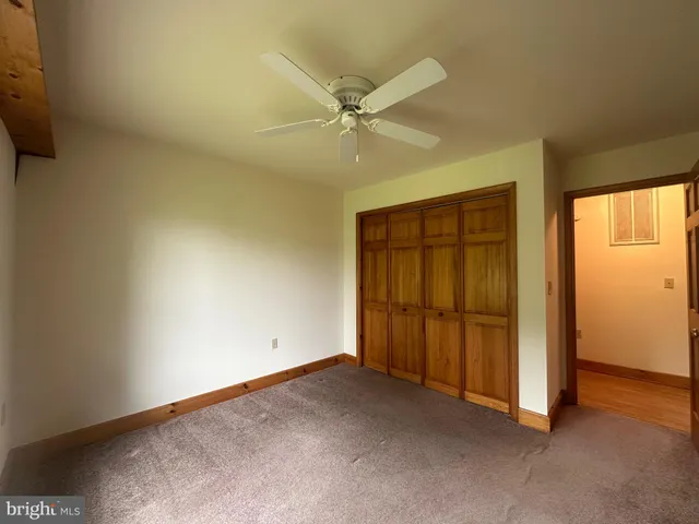 an empty room with windows and fan