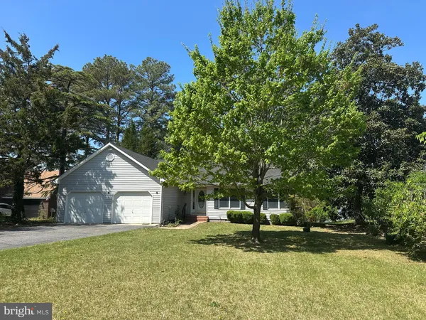 a front view of a house with a yard garage and trees