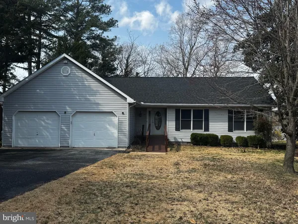 a front view of a house with yard and trees