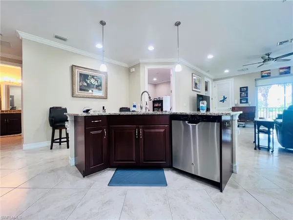 a kitchen with stainless steel appliances granite countertop a stove a sink a refrigerator and a dining table with wooden floor