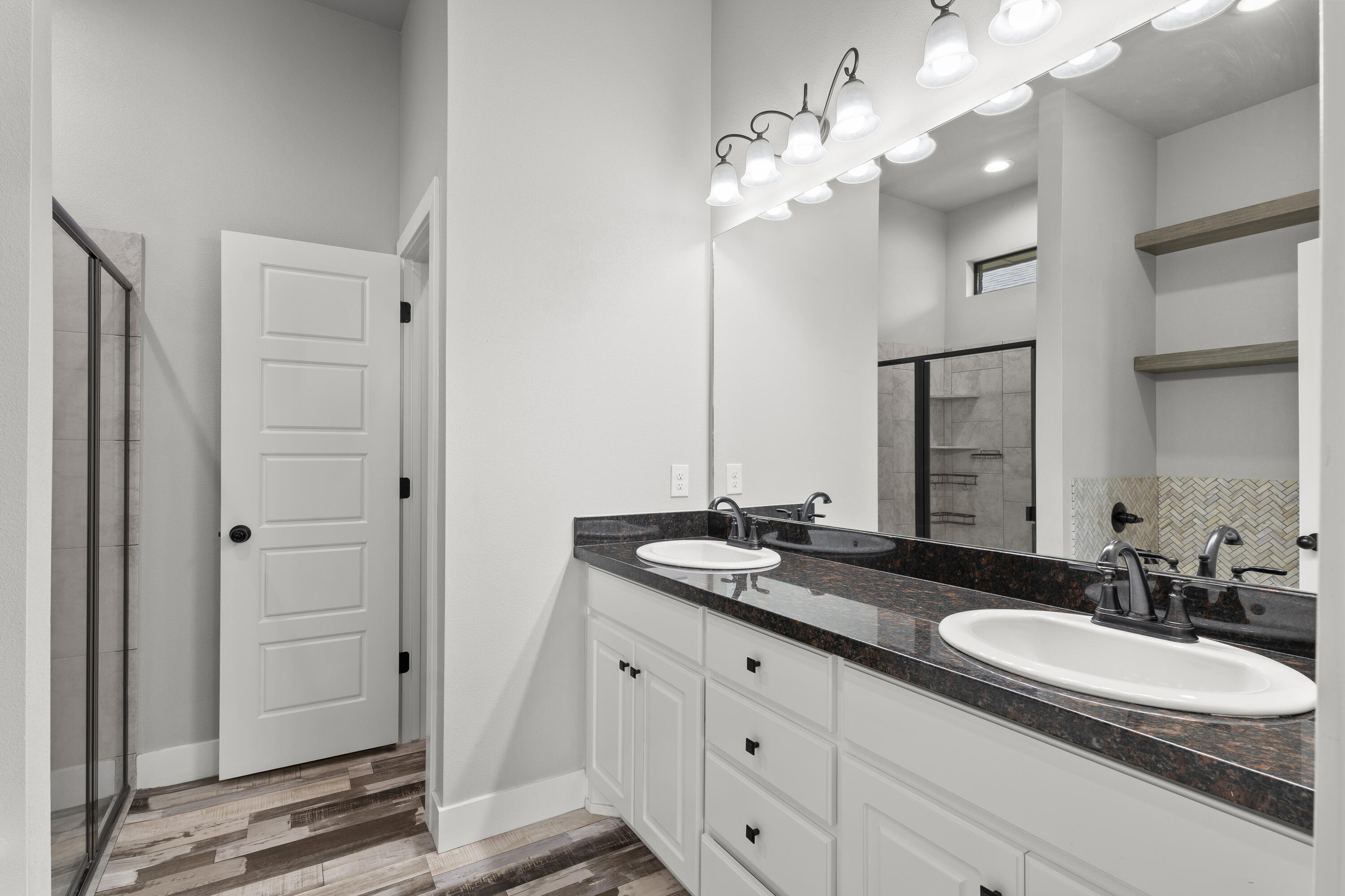 7605 58th Street Lubbock, TX 79407 - Photo 11 of 19 a bathroom with a granite countertop sink a light fixture and a mirror