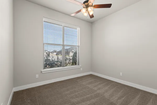 an empty room with a window and a fan