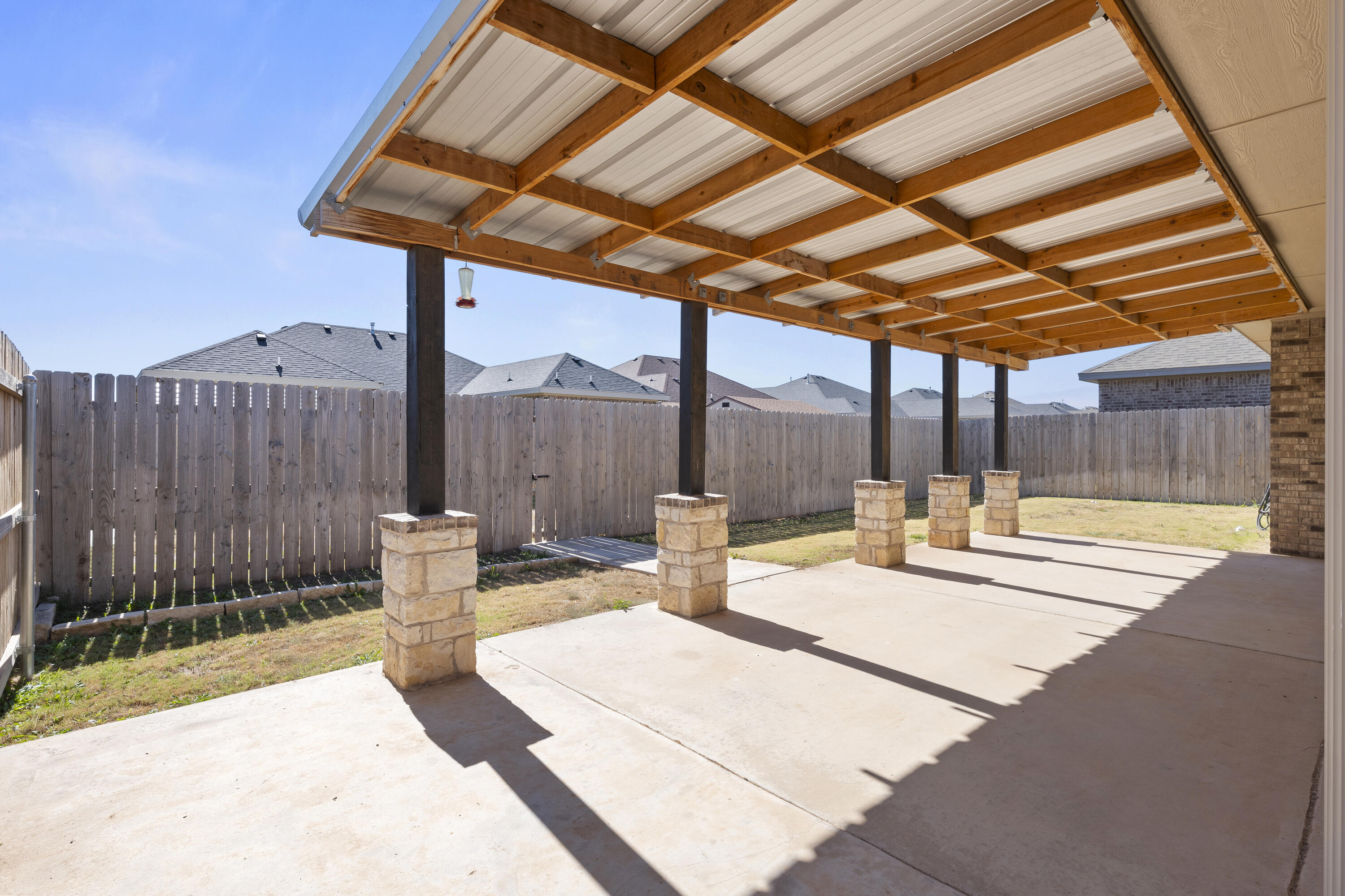 7605 58th Street Lubbock, TX 79407 - Photo 19 of 19 a view of a patio with a table and chairs and wooden fence