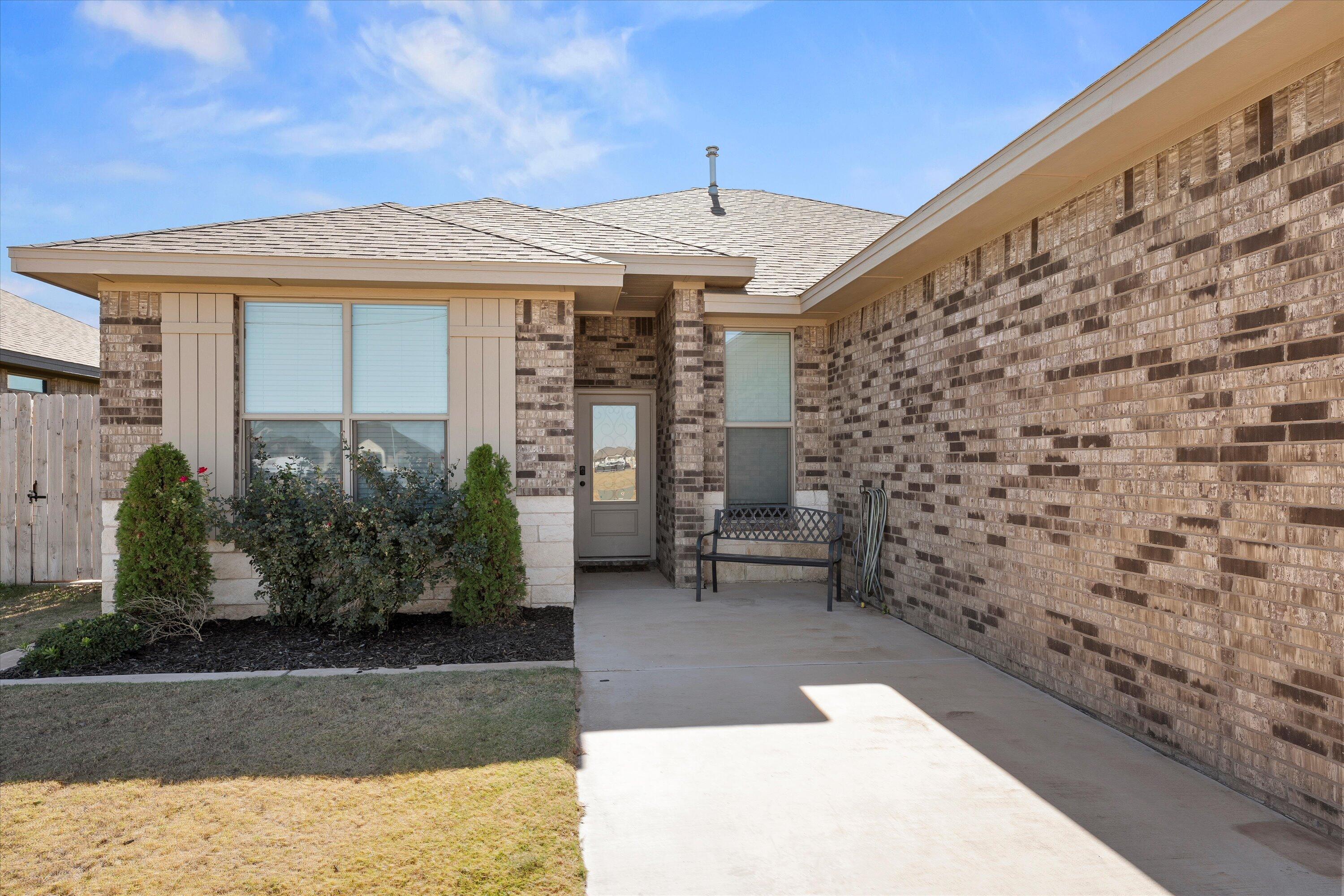 7605 58th Street Lubbock, TX 79407 - Photo 2 of 19 a front view of a house with a garden