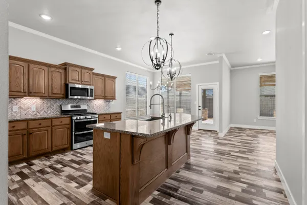 a kitchen with stainless steel appliances granite countertop a sink stove and refrigerator