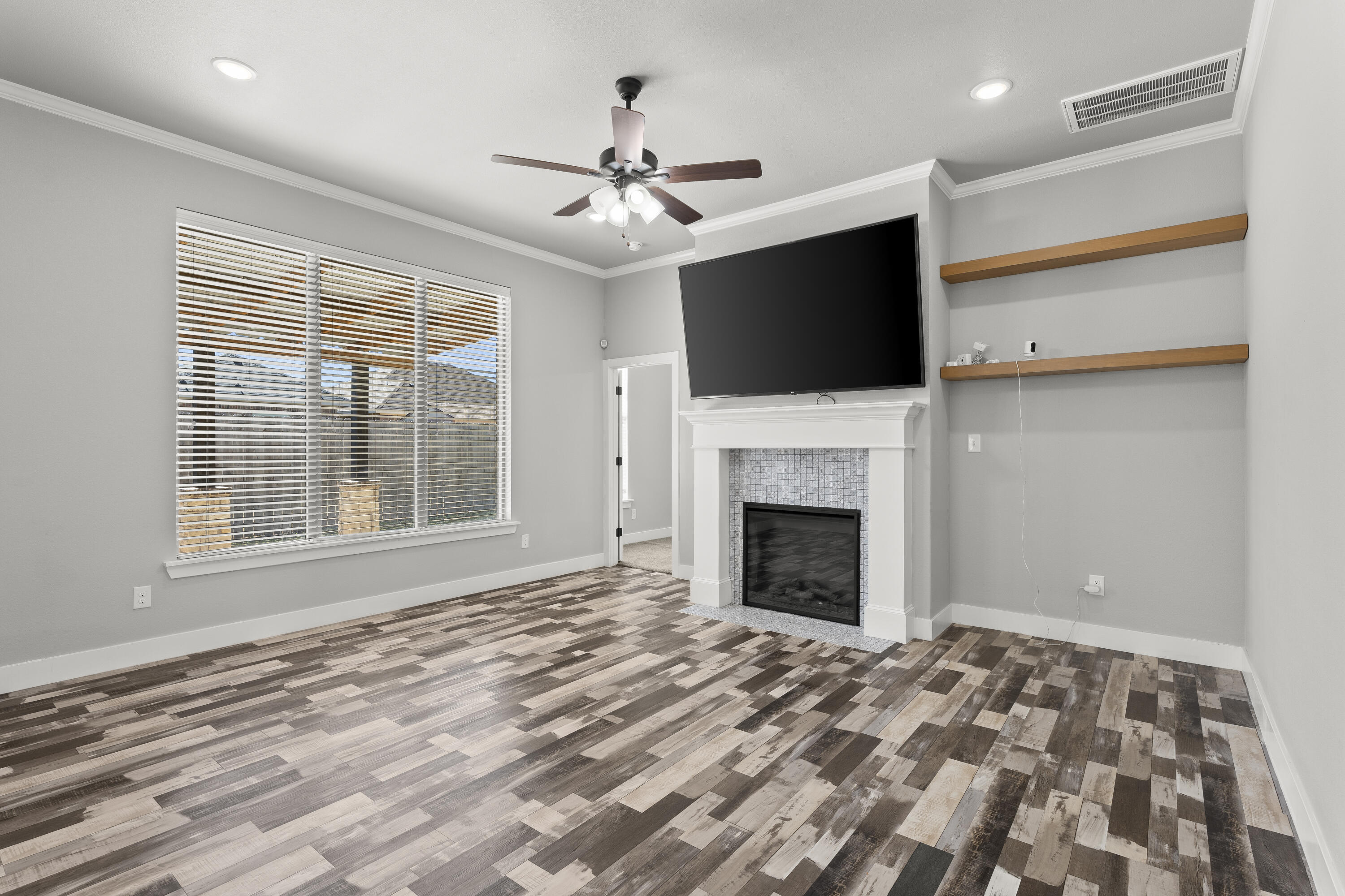 7605 58th Street Lubbock, TX 79407 - Photo 4 of 19 a view of an empty room with a fireplace and a window