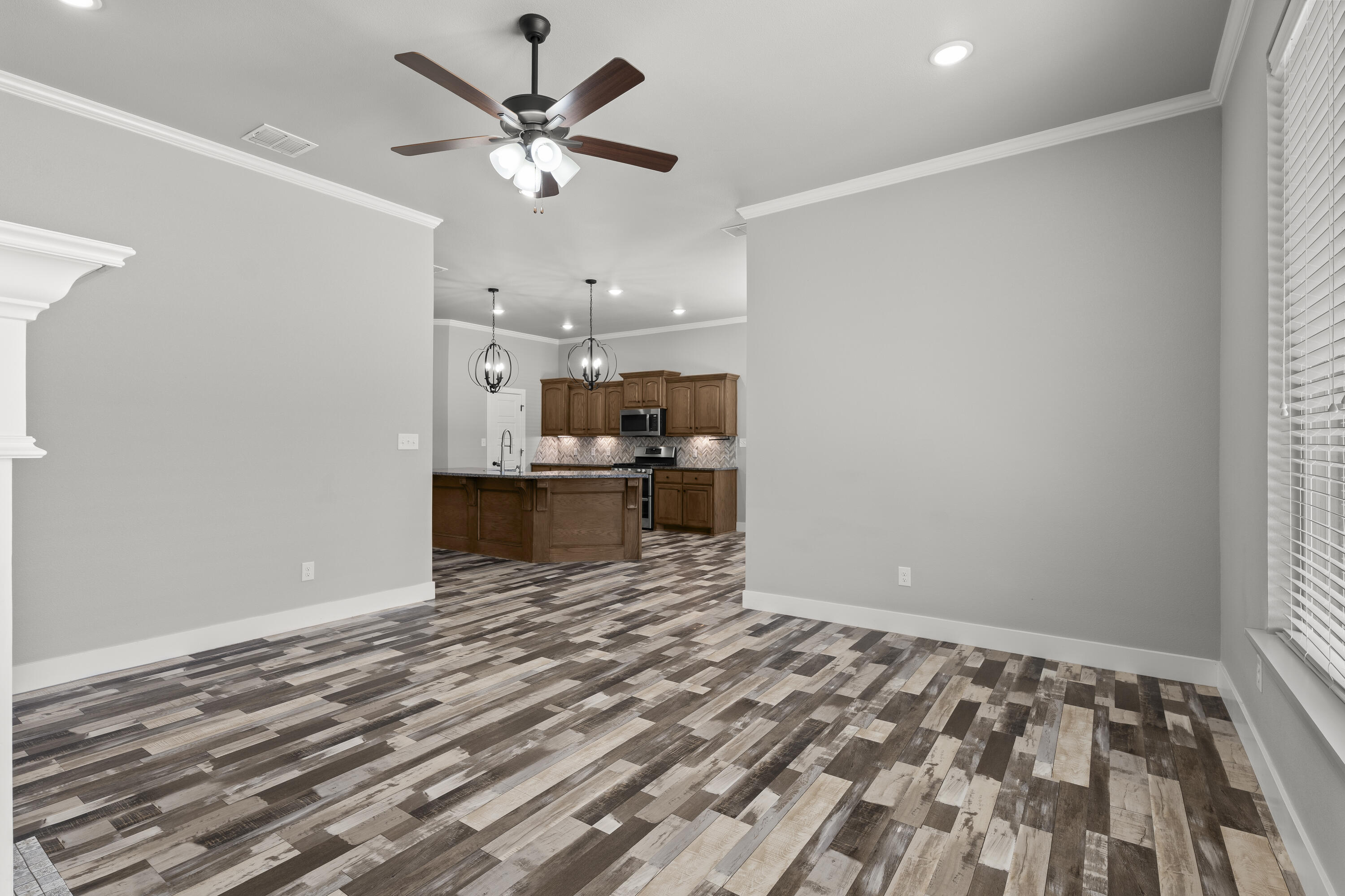 7605 58th Street Lubbock, TX 79407 - Photo 5 of 19 a view of kitchen and empty room with wooden floor