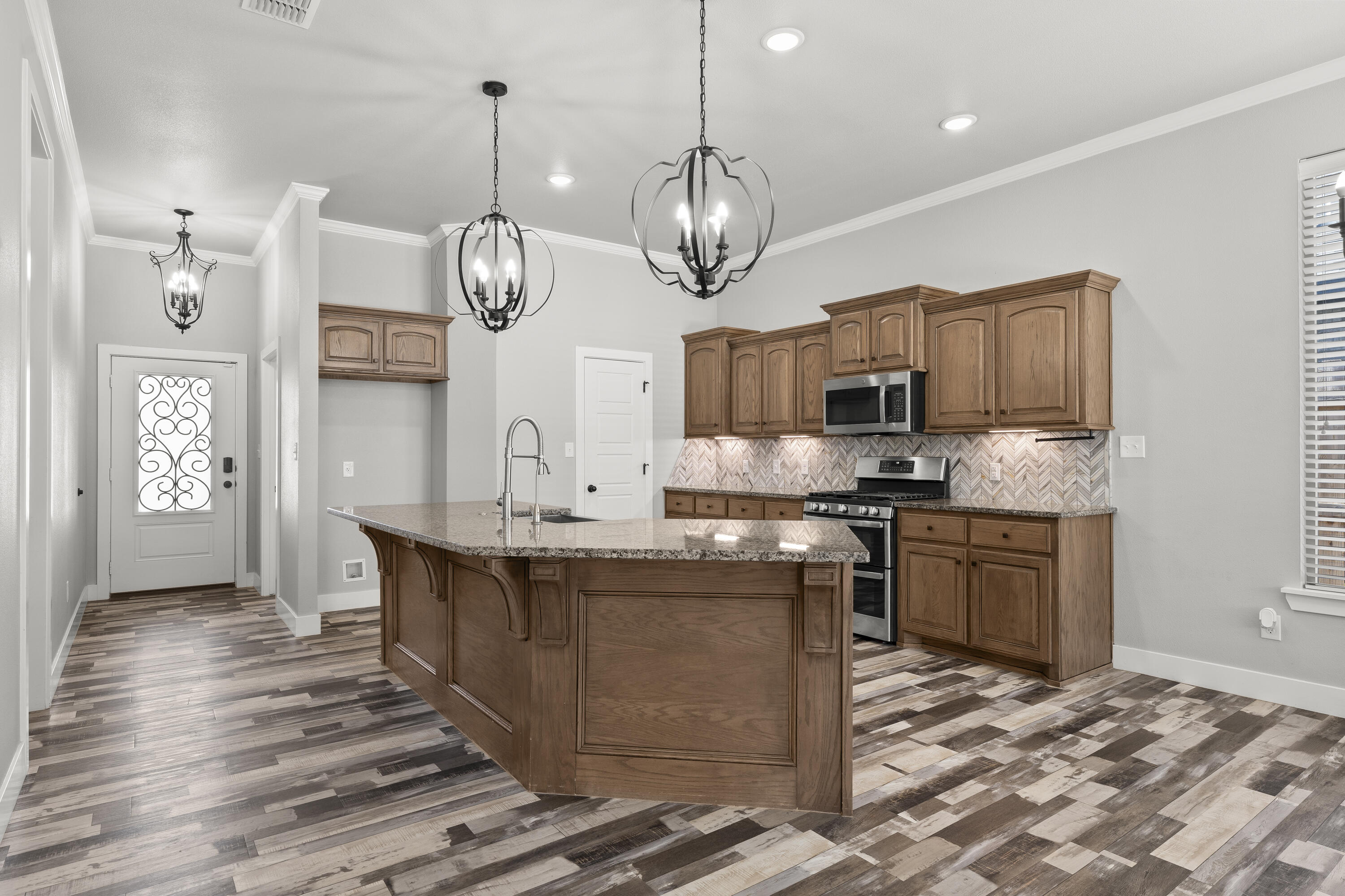 7605 58th Street Lubbock, TX 79407 - Photo 6 of 19 a kitchen with stainless steel appliances granite countertop a sink a stove top oven a clock and cabinets