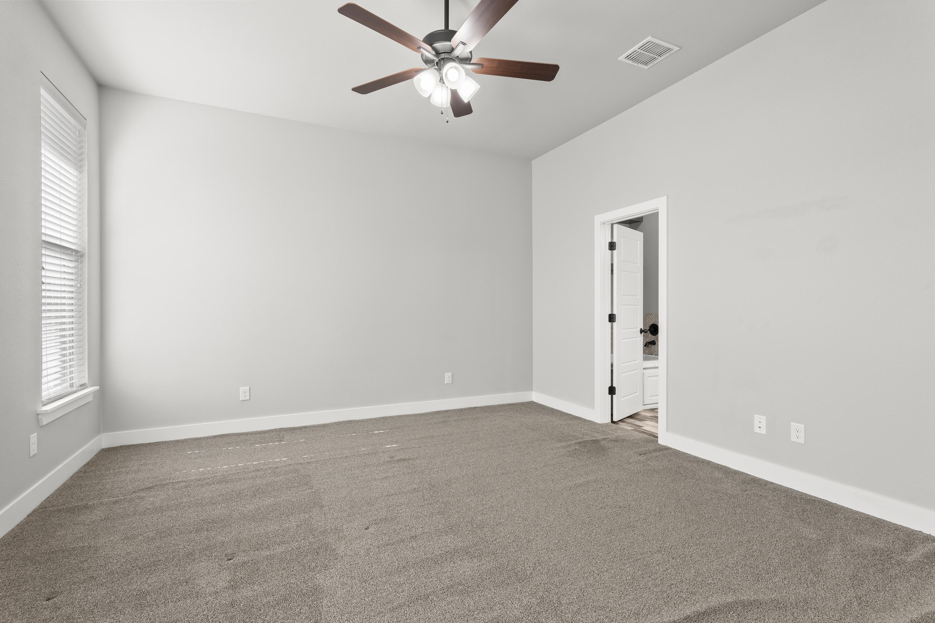 7605 58th Street Lubbock, TX 79407 - Photo 8 of 19 an empty room with windows and fan