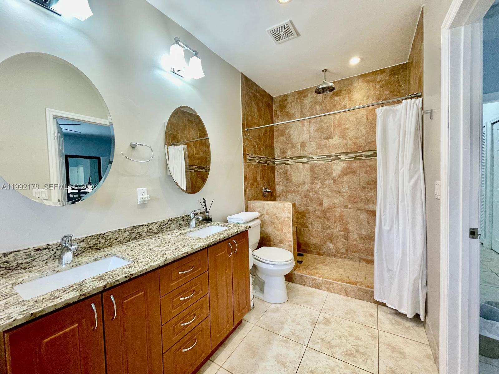 5820 Southwest 113th Court Miami, FL 33173 - Photo 13 of 22 a bathroom with a double vanity sink mirror and toilet