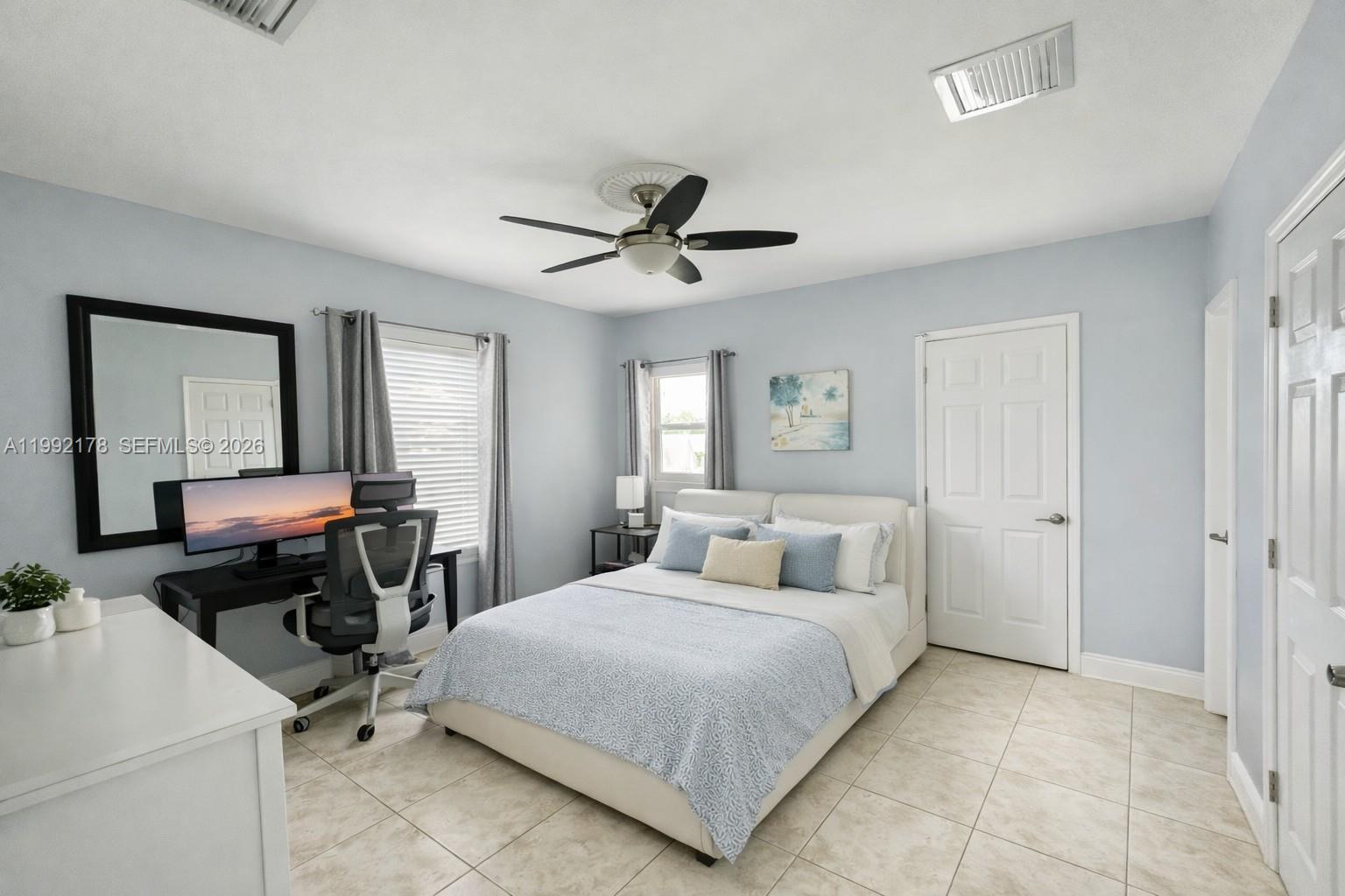 5820 Southwest 113th Court Miami, FL 33173 - Photo 9 of 22 a bedroom with a bed a table and a chandelier