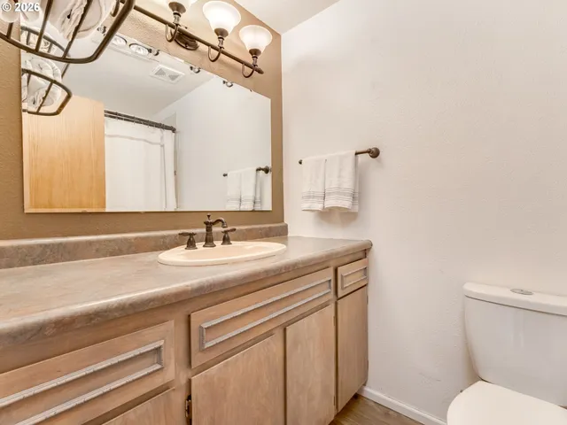 a view of a room with wooden floor fan and windows