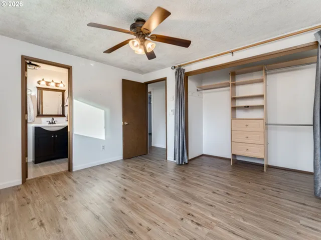 a bedroom with a large bed a flat tv screen and dresser