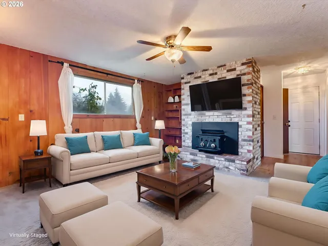 a living room with furniture a flat screen tv and a fireplace