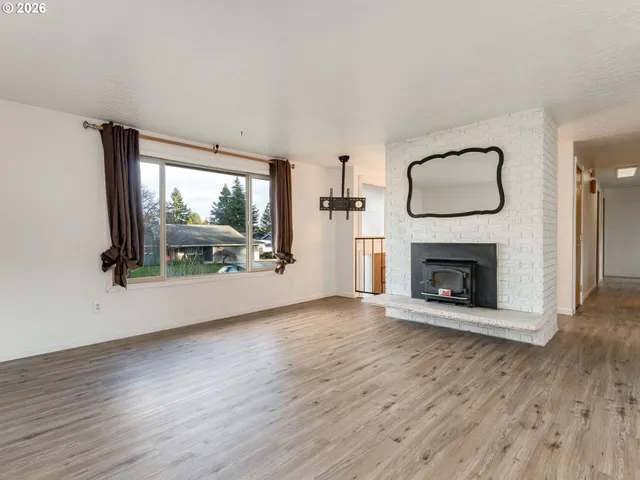a view of a livingroom with wooden floor and a fireplace