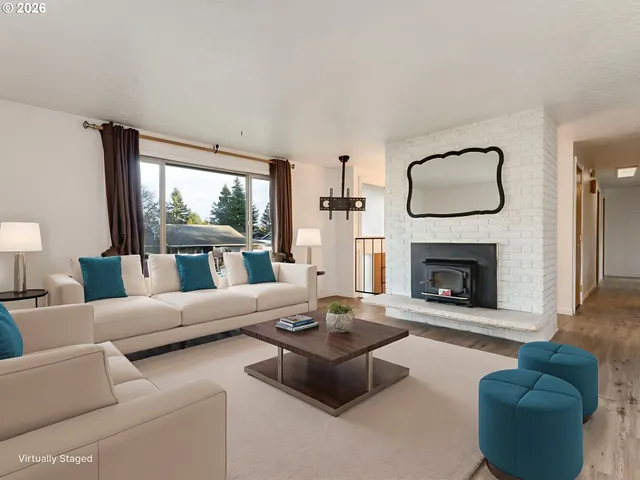 a living room with furniture a fireplace and a large window