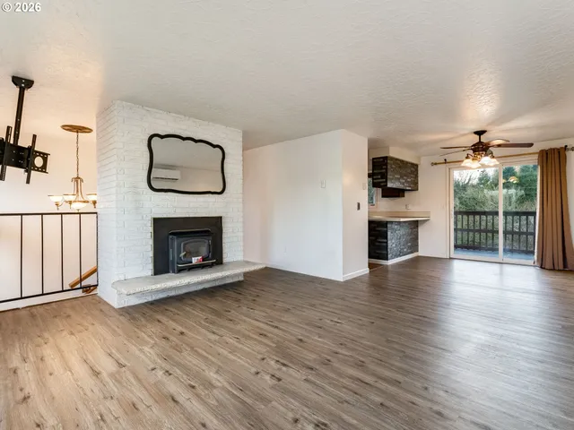 a view of a livingroom with a fireplace wooden floor and window