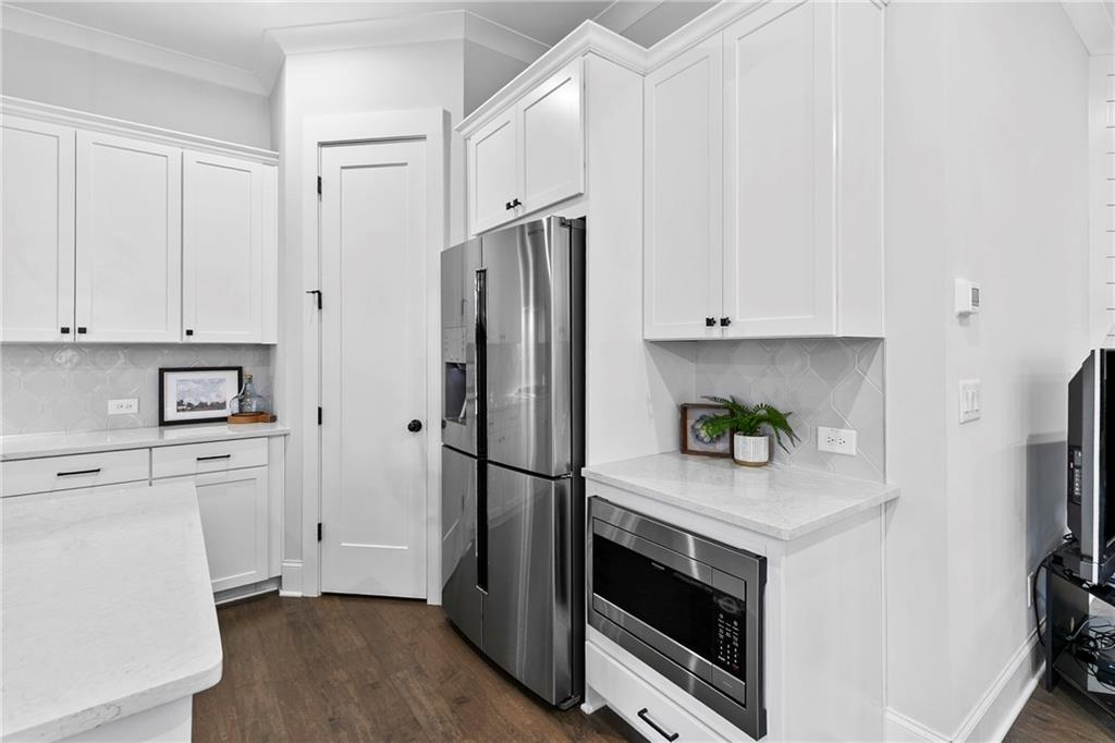120 Meadow Mill Road Woodstock, GA 30188 - Photo 3 of 56 a kitchen with stainless steel appliances white cabinets and a refrigerator