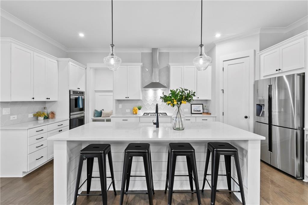 120 Meadow Mill Road Woodstock, GA 30188 - Photo 7 of 56 a kitchen with stainless steel appliances granite countertop a dining table chairs refrigerator and microwave