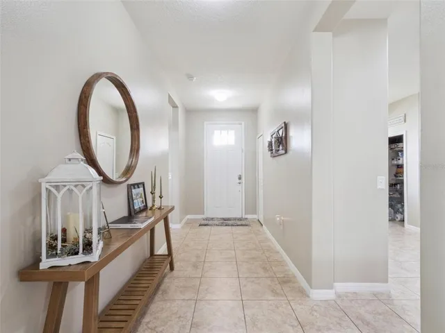 a view of a hallway with entryway wooden floor and a chandelier