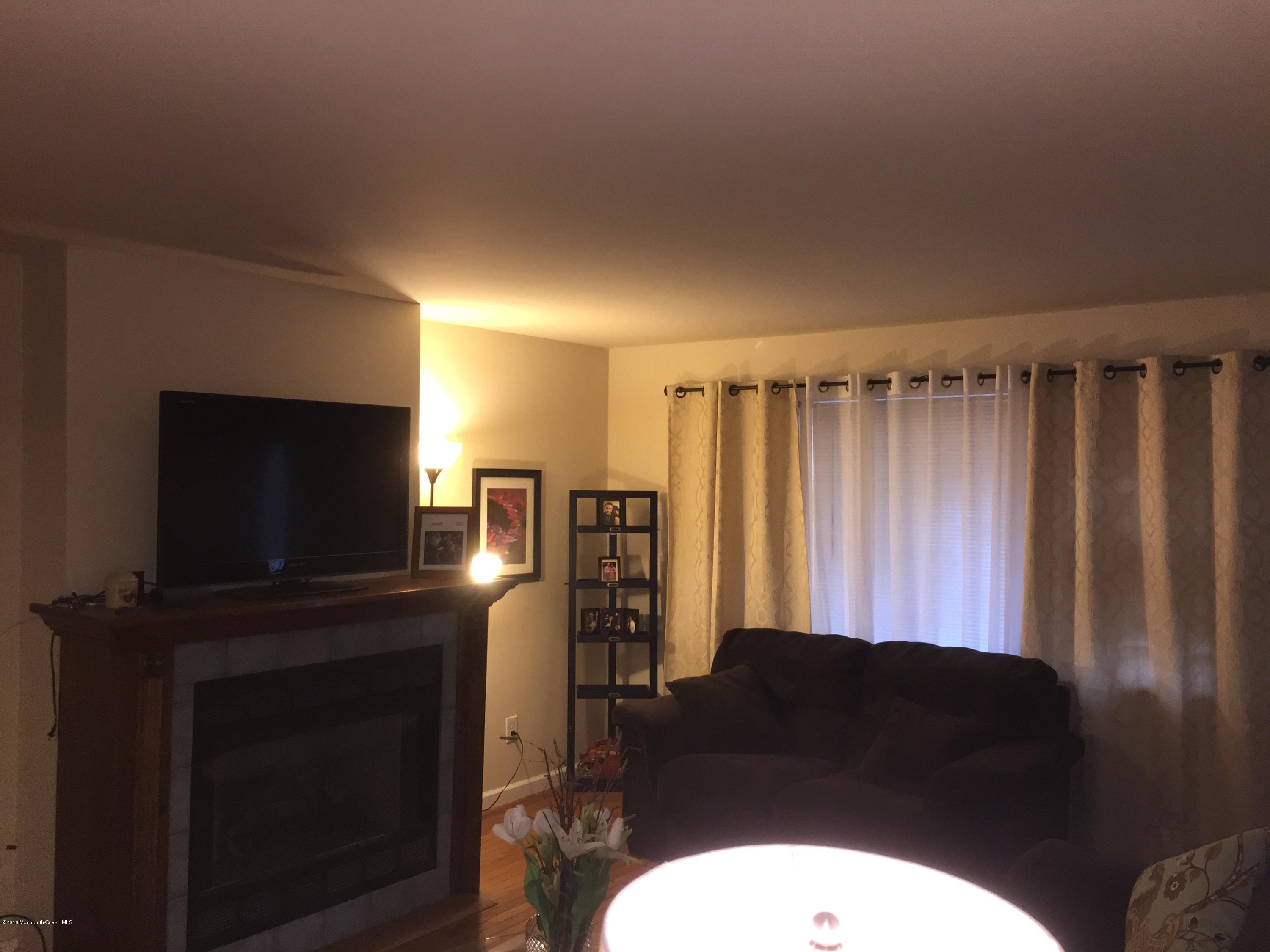 417 Couse Road Neptune Township, NJ 07753 - Photo 3 of 26 a living room with furniture a flat screen tv and a fireplace