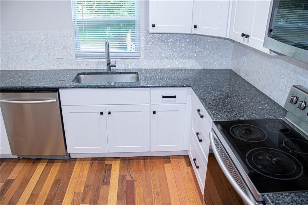 1962 Village Parkway Smyrna, GA 30080 - Photo 14 of 55 a kitchen with granite countertop a sink a stove and cabinets