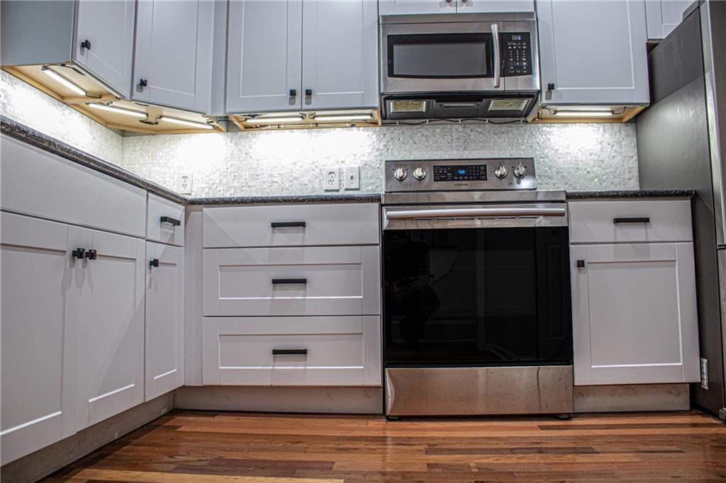 1962 Village Parkway Smyrna, GA 30080 - Photo 19 of 55 a kitchen with stainless steel appliances granite countertop a stove microwave and refrigerator