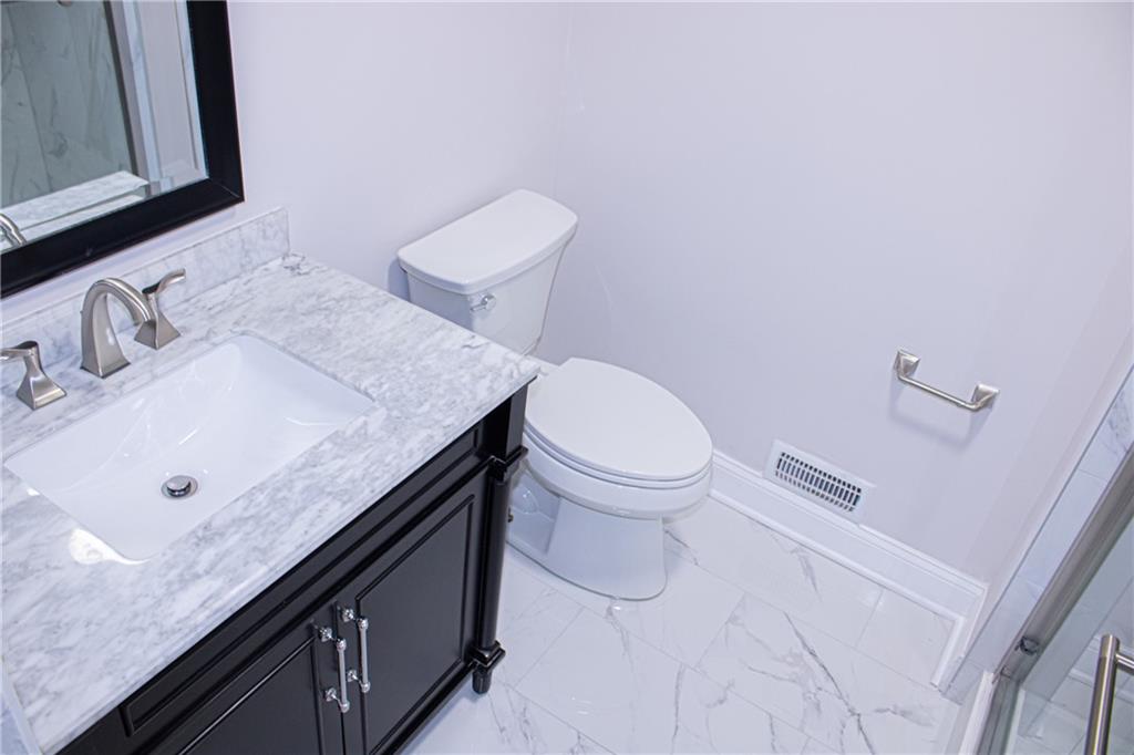 1962 Village Parkway Smyrna, GA 30080 - Photo 31 of 55 a bathroom with a granite countertop sink a toilet and a mirror