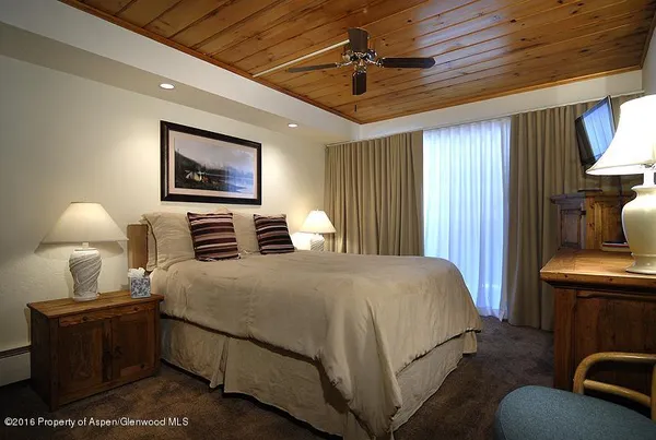 a bedroom with a bed and a lamp on dresser