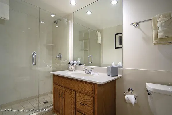 a bathroom with a sink mirror and a toilet