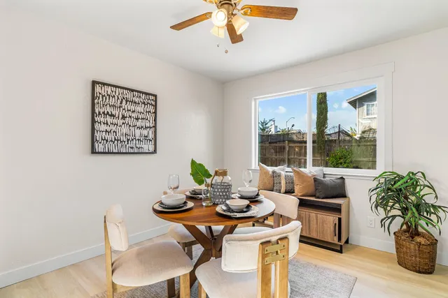 a dining room with furniture potted plants and wooden floor