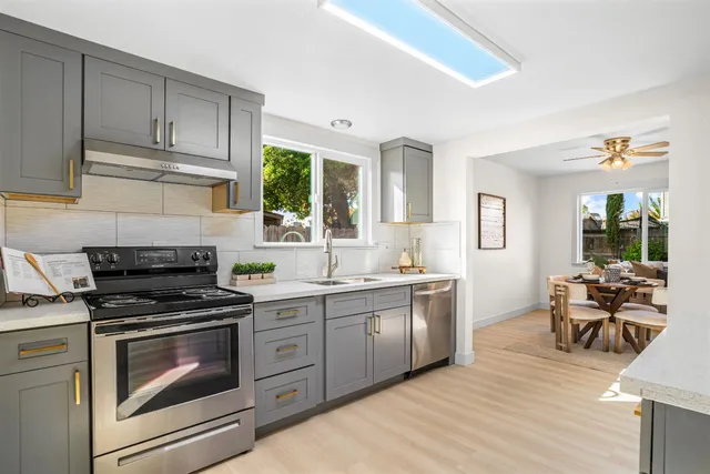 a kitchen with granite countertop a stove a sink and wooden floors