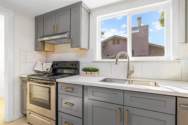 a kitchen with white cabinets and appliances